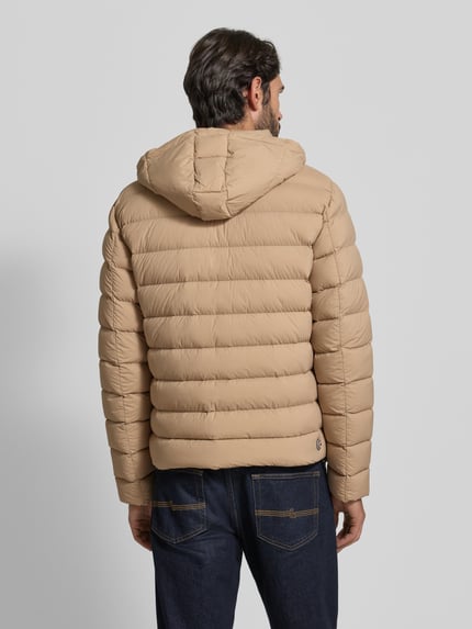 Männermodel trägt Steppjacke mit Kapuze von Colmar Originals in Beige, Regular-Fit, mit Reißverschluss und Eingrifftaschen, Ganzkörperansicht Rückansicht. Rückenlänge 66 cm, Schulterbreite 42 cm, Brustweite 56 cm, Ärmellänge 66 cm bei Größe 50.