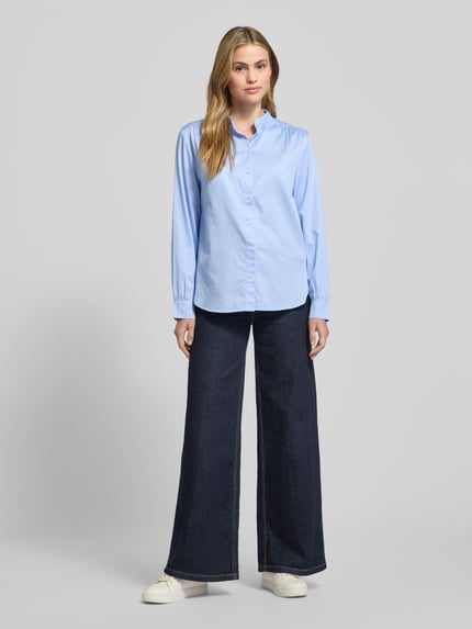 Frauenmodel trägt Regular Fit Hemdbluse aus reiner Baumwolle von Marc O'Polo in Hellblau mit Stehkragen, Knopfleiste, Langarm, unifarben, Ganzkörperansicht von vorne.