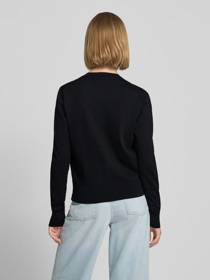 Frauenmodel trägt schwarze Slim Fit Strickjacke aus Baumwoll-Mix von Polo Ralph Lauren zu hellblauen Jeans, Ganzkörperansicht Rückansicht. Damen Strickjacke von Polo Ralph Lauren.