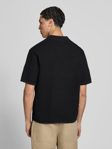 Męski model nosi Regular Fit Poloshirt mit V-Ausschnitt von Jack & Jones z bawełny, czarny, krój regular fit, długość tyłu 67 cm, Ganzkörperansicht Rückansicht.