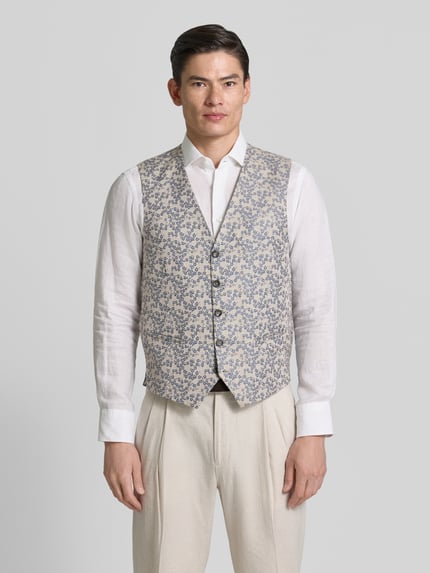 Männermodel trägt Regular Fit Weste mit floralem Allover-Stitching von CG - Club of Gents im Material-Mix mit Paspeltaschen, Knopfleiste, Ganzkörperansicht von vorne. Rückenlänge bei Größe 50: 62 cm, Schulterbreite: 39 cm, Brustweite: 60 cm.