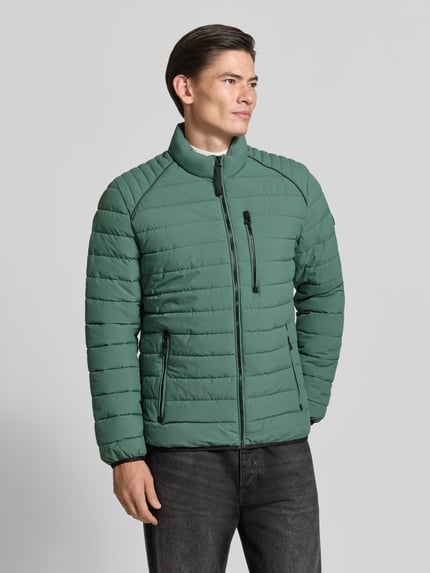 Männermodel trägt Steppjacke mit Stehkragen und Reißverschlusstaschen von LERROS in Grün, dezente Steppung, Ganzkörperansicht von vorne, Regular Fit, Länge 69 cm, Schulterbreite 46 cm, Brustweite 60 cm, Ärmellänge 69 cm.