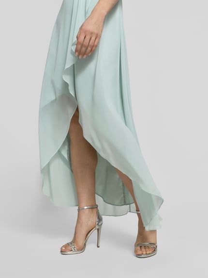 Vrouwenmodel draagt 'Midikleid aus Chiffon met diepe V-hals' van Jake*s Cocktail, lichtgroen, volants, tailleband, detailopname onderlichaam