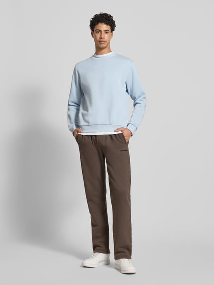 Männermodel trägt Sweatshirt mit gerippten Abschlüssen Modell 'BRADLEY' von JACK & JONES im Regular-Fit, Material-Mix, Ganzkörperansicht von vorne.