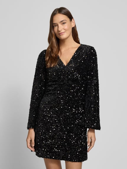 Frauenmodel trägt Minikleid mit Pailletten Modell 'BARINA' von Vila, schwarz, A-Linie, V-Ausschnitt, Ganzkörperansicht von vorne.