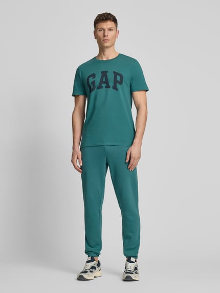 Männermodel trägt T-Shirt mit Logo und Rundhalsausschnitt von GAP, Herren T-Shirt, Reine Baumwolle, Regular-Fit, Logo, Rückenlänge 72 cm, Ganzkörperansicht von vorne.