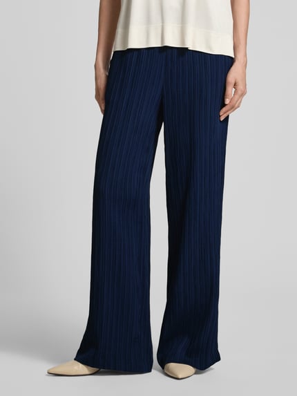 Frauenmodel trägt Hose mit Strukturmuster Modell 'Grsvalse' von FREE/QUENT in Dunkelblau, Material-Mix, weites Bein, Nahaufnahme Unterkörper.