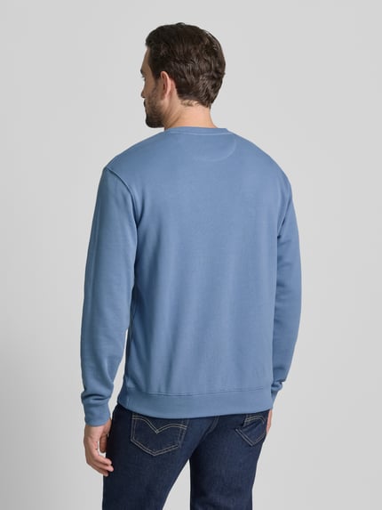 Männermodel trägt Sweatshirt mit Label-Detail van Scotch & Soda in blauw, katoen, losse pasvorm, ribboorden, rugaanzicht, Ganzkörperansicht Rückansicht.
