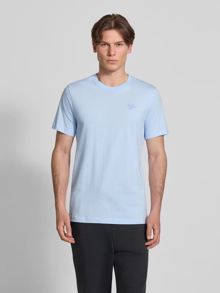 Männermodel trägt T-Shirt mit Label-Stitching von Nike, Hellblau, Reine Baumwolle, Regular-Fit, Rundhalsausschnitt, Rückenlänge 73 cm, Ganzkörperansicht von vorne.