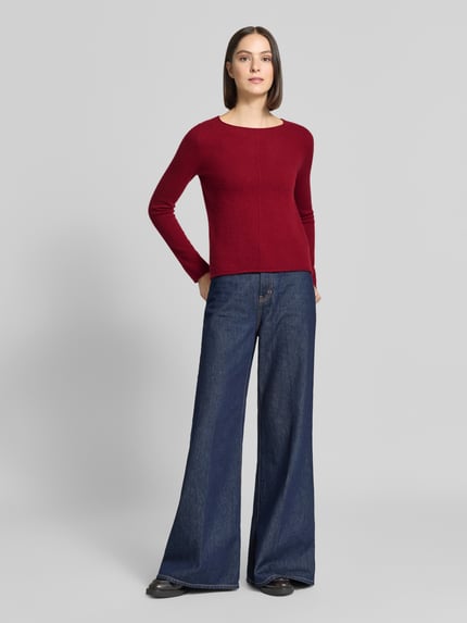 Frauenmodel trägt Regular Fit Strickpullover aus reinem Kaschmir von Christian Berg Woman in Dunkelrot mit Ziernaht, Rundhalsausschnitt, Ganzkörperansicht von vorne.
