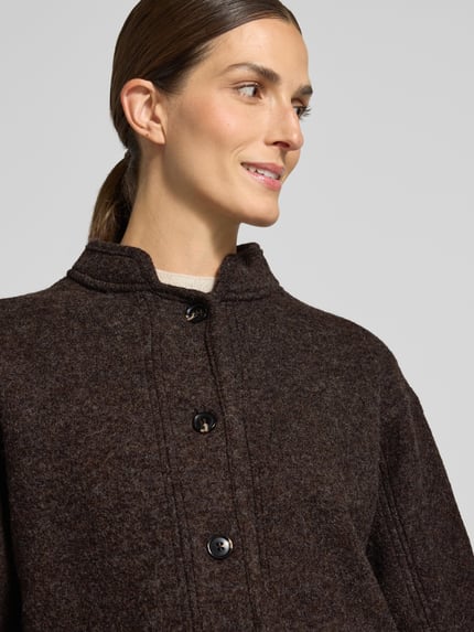 Vrouwenmodel draagt Jacke mit Stehkragen und Paspeltaschen van Stefanel in donkerbruin, puur katoen, regular fit, knoopsluiting, paspelzakken, ruglengte maat S 57 cm, schouderbreedte 53 cm, borstwijdte 58 cm, mouwlengte 59 cm, Nahaufnahme bovenlichaam.