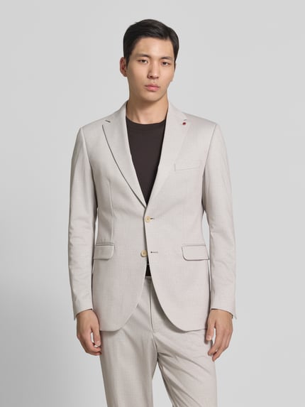 Männermodel trägt Regular Fit Sakko mit Viskose-Anteil Modell 'Cavin' von CG - Club of Gents in Beige, Elastischer-Material-Mix, Ganzkörperansicht von vorne. Rückenlänge 75 cm, Schulterbreite 44 cm, Ärmellänge 64 cm, Reverskragen, Brusttasche, Pattentaschen, Logo-Detail.