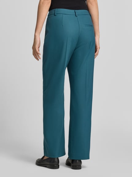 Männermodel trägt Stoffhose mit Bügelfalte und französischen Eingrifftaschen von COMMA in Petrol, Material-Mix, Straight Fit, Ganzkörperansicht Rückansicht