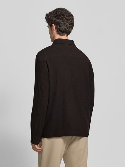 Männermodel trägt Blouson Modell 'Dellin' von STRELLSON in Schwarz mit Umlegekragen und Knopfleiste, Ganzkörperansicht Rückansicht.
