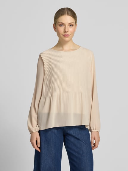 Frauenmodel trägt Bluse mit Plisseefalten Modell 'Ev44a' von ZABAIONE aus beigem Chiffon, elastische Ärmelabschlüsse, Ganzkörperansicht von vorne.