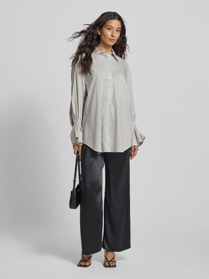 Frauenmodel trägt schwarze Wide Leg Stoffhose mit elastischem Bund von ZABAIONE, glatte Textur, Ganzkörperansicht von vorne.