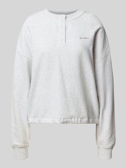 Produktfoto, Boxy Fit Sweatshirt mit Knopfleiste Modell 'Aven' von OH APRIL aus bawełna, okrągły dekolt, listwa guzikowa, wyhaftowane logo