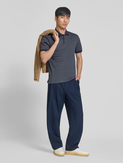 Männermodel trägt Regular Fit Poloshirt aus reiner Baumwolle Modell 'H-PARLAY 102' von BOSS in Bi-Color Optik, Ganzkörperansicht von vorne.