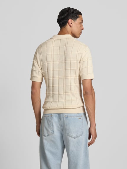 Männermodel trägt Modern Fit Poloshirt mit Logo-Stitching von REVIEW aus Reine Baumwolle, Strukturmuster, Polokragen, kurzer Reißverschluss, Rückenlänge bei Größe M: 66 cm, Ganzkörperansicht Rückansicht.