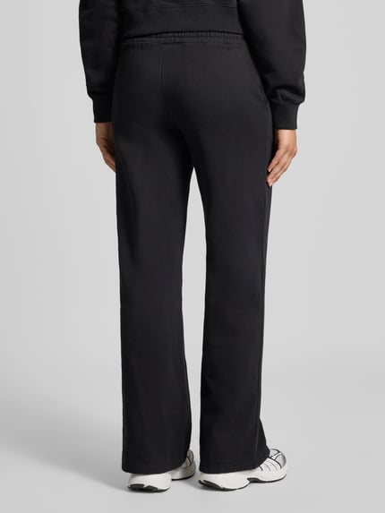 Frauenmodel trägt Wide Fit Sweatpants aus Baumwoll-Mix Modell 'ANNI' von PEGADOR, Schwarz, elastischer Bund, Ganzkörperansicht Rückansicht.