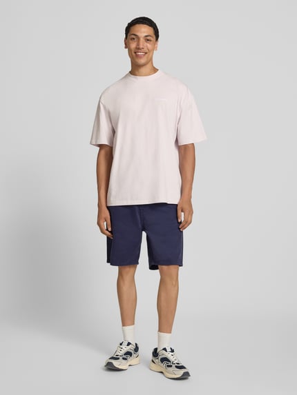 Männermodel trägt Bermudas im 5-Pocket-Design Modell 'TONY ORIGINAL' von Jack & Jones in Dunkelblau aus Reine Baumwolle, Straight Fit, Knopf- und Reißverschluss, Bundweite in Größe M 42 cm, Innenbeinlänge 20 cm, Ganzkörperansicht von vorne.