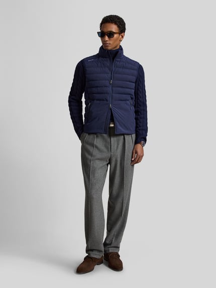 Männermodel trägt Regular Fit Weste mit Logo-Stitching Modell 'PIECE DYED' von Polo Ralph Lauren in Dunkelblau, Ganzkörperansicht von vorne. Herren Weste von Polo Ralph Lauren.