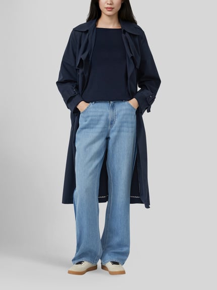 Frauenmodel trägt Regular Fit Pullover aus Baumwoll-Viskose-Mix von s.Oliver RED LABEL in Dunkelblau, kombiniert mit Jeans und Mantel, Ganzkörperansicht von vorne.