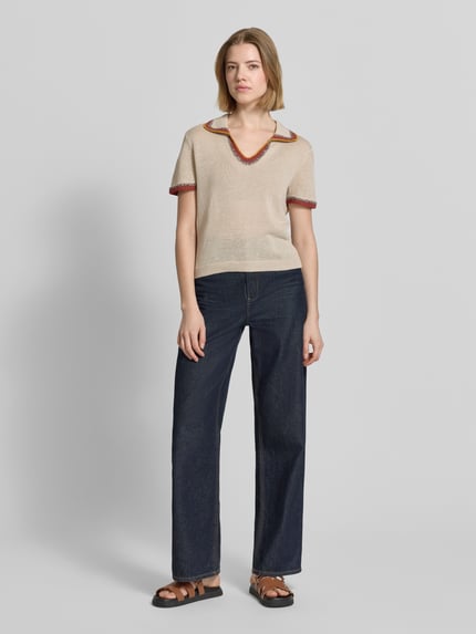 Vrouwenmodel draagt T-shirt in strick-optik met contrastkante van Stefanel, mix van vlas en katoen, straight fit, polokraag, ruglengte bij maat S 49 cm, tricotlook in beige met contrasterende randen, voorkant volledige lichaamsopname.