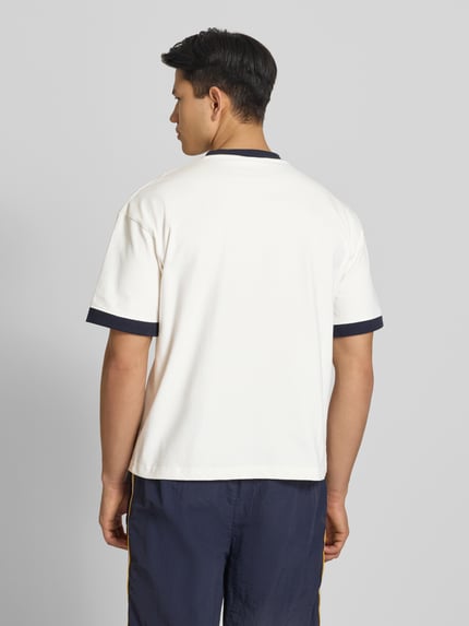 Männermodel trägt T-Shirt mit Label-Stitching Modell 'Rush' von PROHIBITED in Weiß mit dunkelblauen Details, Baumwolle, Ganzkörperansicht Rückansicht.