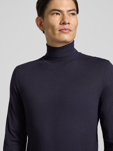 Männermodel trägt Slim Fit Rollkragenpullover aus Viskose-Mix mit Rippbündchen von MCNEAL, dunkle Farbe, Nahaufnahme Oberkörper.