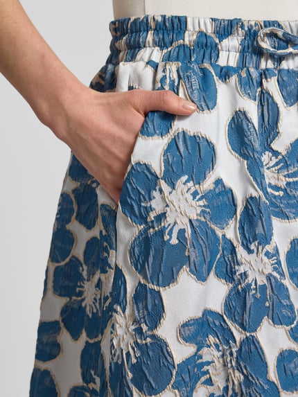 Vrouwenmodel draagt midirok met elastische band model 'Bristol' van LOLLYS LAUNDRY, materiaalmix met stretch, A-lijn, all-over look, detailopname.