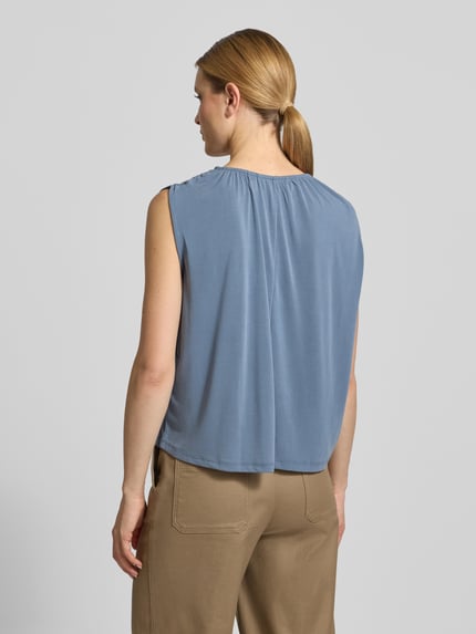 Frauenmodel trägt Loose Fit Blusentop aus Modal-Mix Modell 'FILLI' von Vero Moda in Uni-Blau, ohne Ärmel, Ganzkörperansicht Rückansicht.