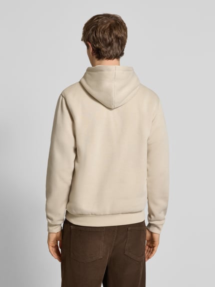 Männermodel trägt Hoodie mit Kapuze Modell 'BRADLEY' von Jack & Jones in Beige, lockerer Schnitt, Baumwoll-Mix, Ganzkörperansicht Rückansicht.