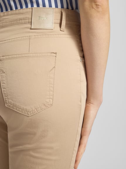 Vrouwenmodel draagt Hose in verkürzter Passform Modell 'Mary' van Brax in beige, katoenmix met lyocell, detailopname achterkant.
