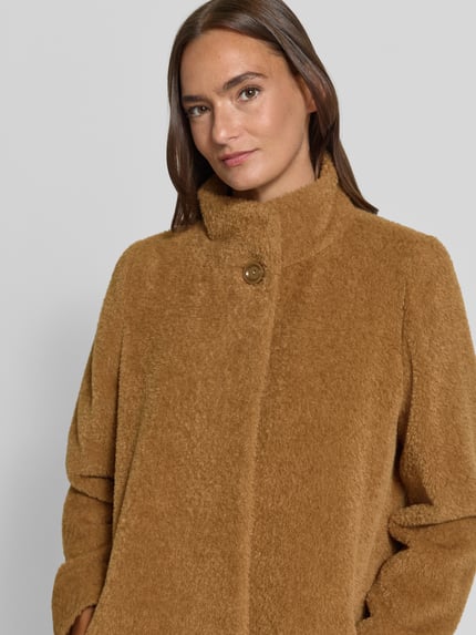 Frauenmodel trägt Mantel aus Schurwolle-Alpaka-Mix mit Stehkragen von ICONS Cinzia Rocca in hellem Braun, Nahaufnahme Oberkörper. Regular Fit, Knopfverschluss, Eingrifftaschen, strukturierte Textur, Schulterbreite 44 cm, Brustweite 51 cm, Ärmellänge 66 cm, Rückenlänge 89 cm bei Größe 36.