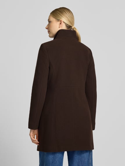 Frauenmodel trägt Regular Fit Mantel aus Woll-Mix mit Kaschmir-Anteil von FUCHS SCHMITT in Dunkelbraun, glatte Textur, Rückenansicht, Ganzkörperansicht Rückansicht. Taillierte Passform, Stehkragen und Knopfleiste sichtbar, Eingrifftaschen angedeutet, schlichte blaue Jeans ergänzen das Bild. Rückenlänge 83 cm, Schulterbreite 41 cm, Brustweite 42 cm, Ärmellänge 64 cm.