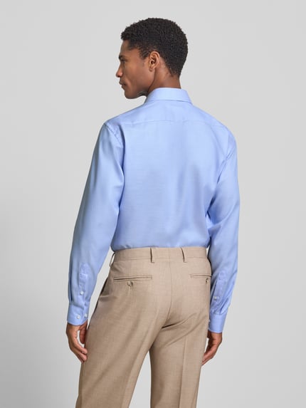 Männermodel trägt Regular Fit Business-Hemd mit Strukturmuster und Kentkragen von Christian Berg Men, Reine Baumwolle, Rückenlänge 78 cm, Schulterbreite 46 cm, Ärmellänge 65 cm, hellblau, feine Textur, Beigehose, Ganzkörperansicht Rückansicht.