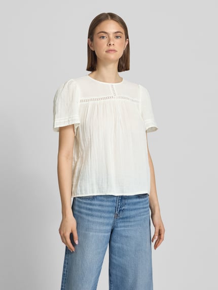 Frauenmodel trägt Relaxed Fit Bluse aus reiner Baumwolle Modell 'SIKKA' von Pieces in Weiß, strukturierte Musselin-Oberfläche, Kurzarm, Ganzkörperansicht von vorne.