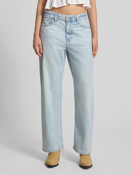Frauenmodel trägt Straight Fit Jeans aus reiner Baumwolle von Calvin Klein Jeans, hellblaue Farbe, lockerer Schnitt, Ganzkörperansicht von vorne.