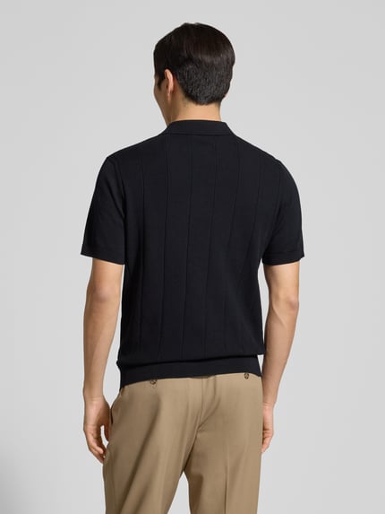 Männermodel trägt Regular Fit Poloshirt aus katoen model 'Pima Primo' van Profuomo, zwarte kleur, rechte lijnen, ruglengte maat M 67 cm, pure katoen, polokraag, geribde boorden, geheel zwart design, achteraanzicht hele lichaam.
