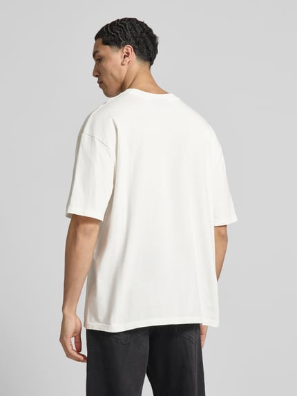 Męski model nosi Oversized T-Shirt mit Logo-Stitching od Pegador, bawełna, krój oversized fit, okrągły dekolt, długość tyłu 73 cm, całkowity widok z tyłu.