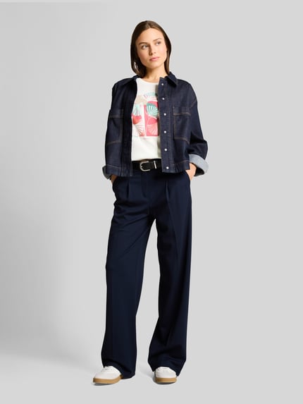 Frauenmodel trägt Regular Fit T-Shirt aus reiner Baumwolle von Tom Tailor in Optik: Unifarben mit Label-Print, Motiv-Print-Stitching, Rundhals, Kurzarm, Jersey, Ganzkörperansicht von vorne.
