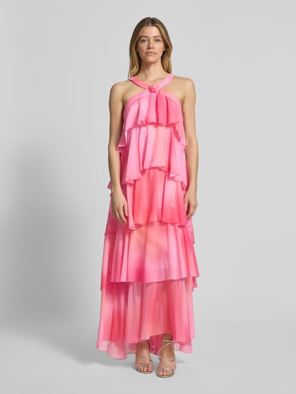 Frauenmodel trägt Volant Abendkleid mit V-Ausschnitt Modell 'FELICIA' von Vero Moda in Unifarbe Pink aus Chiffon, Maxi-Länge, Ganzkörperansicht von vorne.
