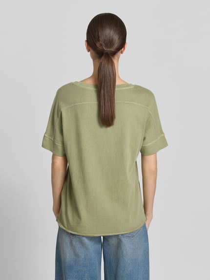 Frauenmodel trägt Relaxed Fit T-Shirt aus reiner Baumwolle von s.Oliver RED LABEL in Optik: Unifarben, Kurzarm, Rollsaum, Logo-Applikation, Ganzkörperansicht Rückansicht.