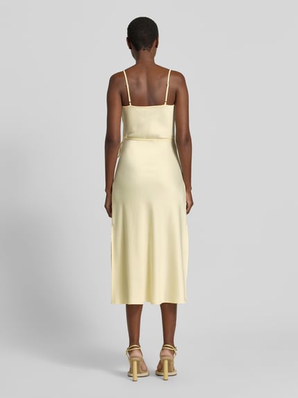 Frauenmodel trägt Midikleid mit Stretch-Anteil Modell 'THEA' von YAS, Elastischer-Material-Mix, Schmales Taillenband, Ganzkörperansicht Rückansicht.