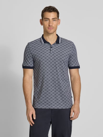 Männermodel trägt Regular Fit Poloshirt mit Logo-Muster Modell 'Jessino' von JOOP! Collection aus reiner Baumwolle, Ganzkörperansicht von vorne.