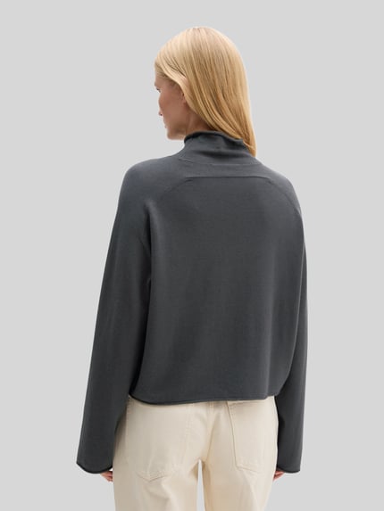 Frauenmodel trägt Rollkragenpullover mit Mock Neck von MARC O'POLO, unifarben, grauer Feinstrick-Wollmix, strukturierte Optik, Loose Fit, Ganzkörperansicht Rückansicht.