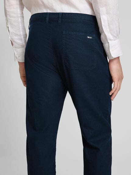 Mannenmodel draagt Relaxed Fit broek uit mix van linnen en katoen van s.Oliver RED LABEL, effen kleuren, achterzak met labelstitching, steekzakken, knoop- en ritssluiting, riemlussen, webware, materiaalverwerking, ganzkörperansicht rückansicht.