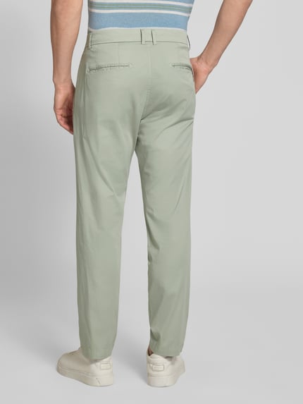 Männermodel trägt Anzughose mit Biesen und französischen Eingrifftaschen von CINQUE in Hellgrün, Straight Fit, Gesäßleistentaschen, Ganzkörperansicht Rückansicht. Baumwoll-Mix mit Stretch-Anteil, Haken-, Knopf- und Reißverschluss, Bundweite 48 cm, Innenbeinlänge 76 cm in Größe 50.