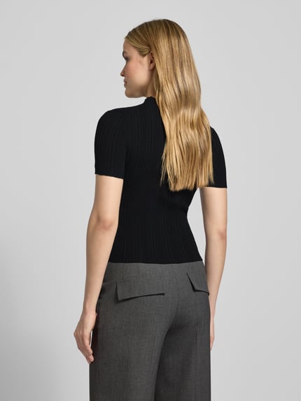 Vrouwenmodel draagt Slim Fit T-Shirt uit viscosemix model 'SARPHAPILK' van HUGO, zwart, ribtextuur, effen, frill afwerking, rugaanzicht.